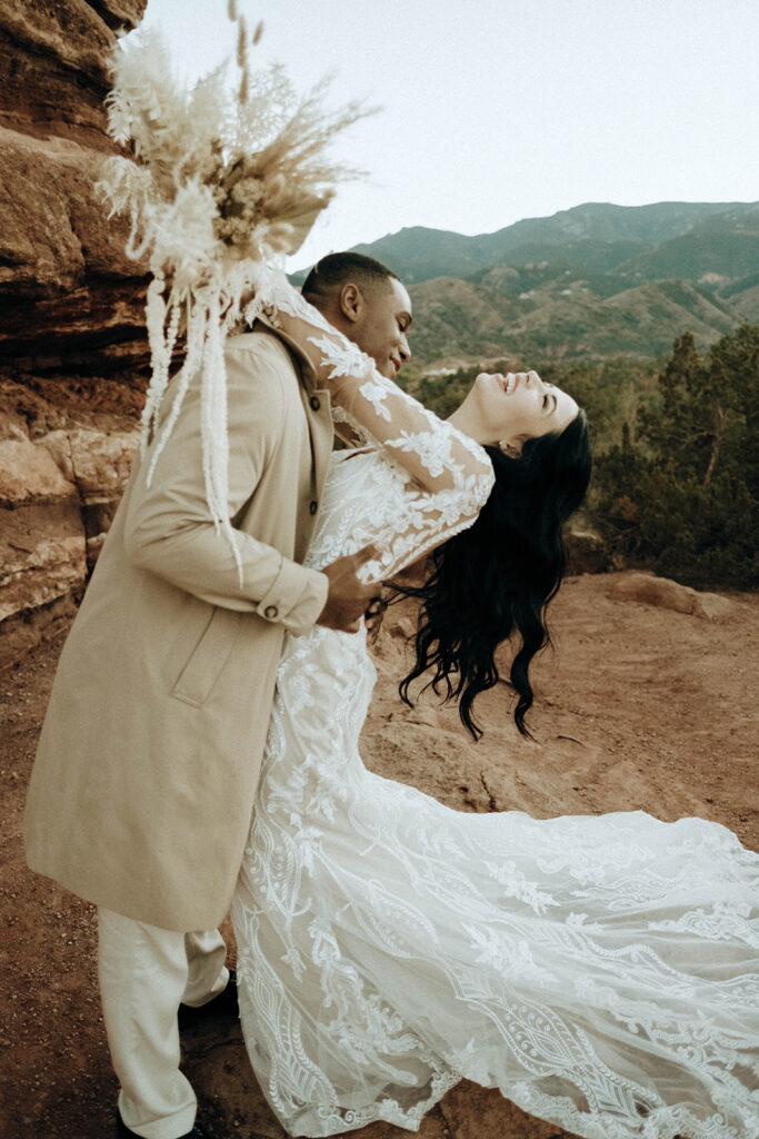 bride and groom at elopement in Colorado Springs multiracial biracial couple elopement lace wedding dress dried bouquet
